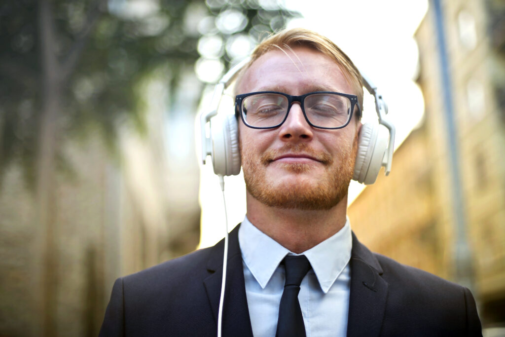 Young while male in business suit wearing headphones