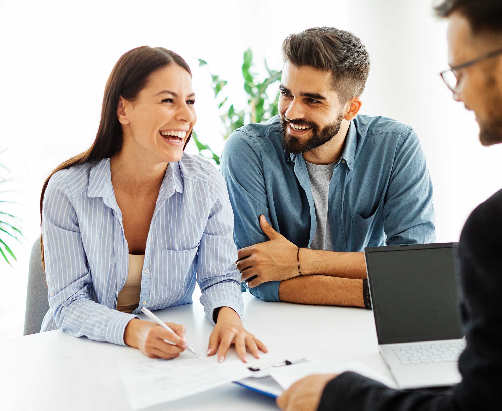 Real estate agent with couple shaking hands closing a deal