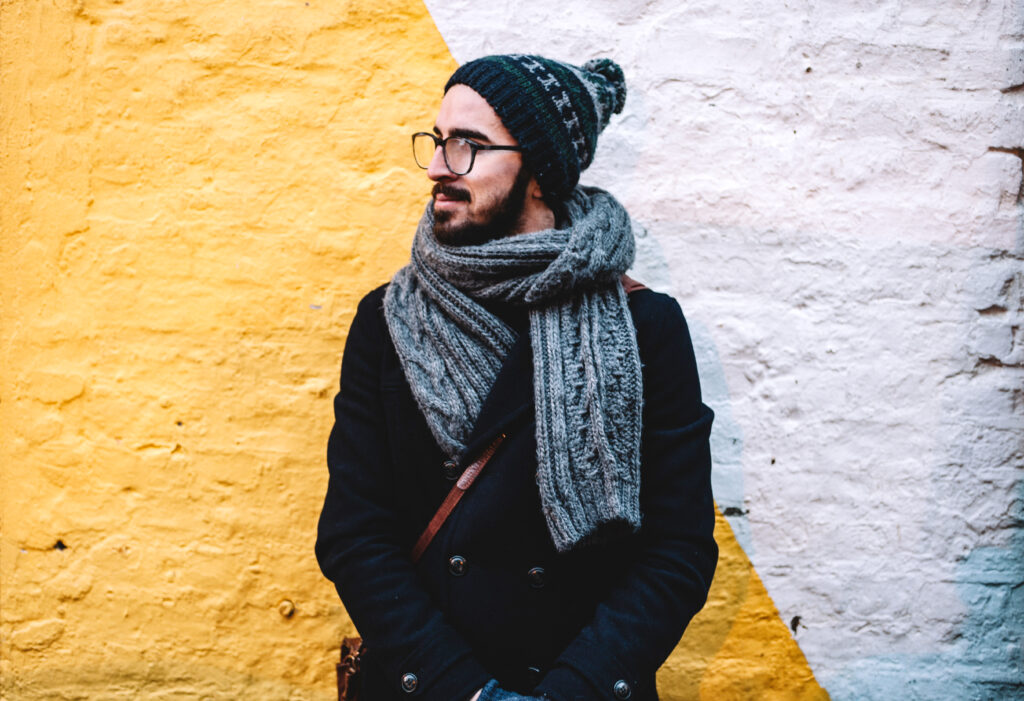 younger man smiling while outside and bundled up in cold weather