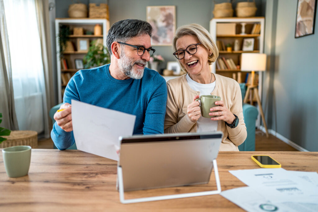 Cheerful mature couple managing retirement planning together