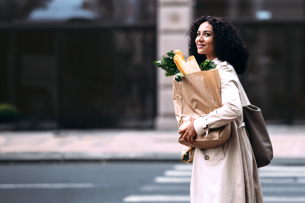 Woman crossing street, carrying a bag of groceries