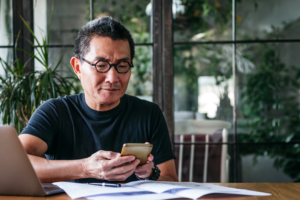 Older male with glasses reviewing his financial monthly expenses