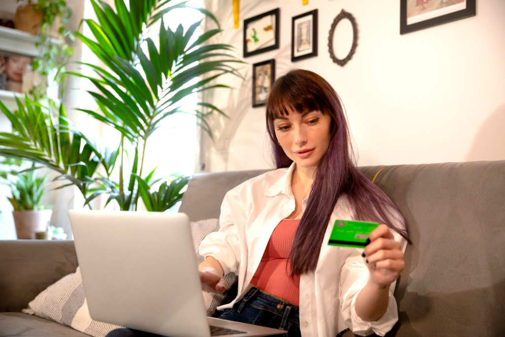 woman reading credit card while using a laptop