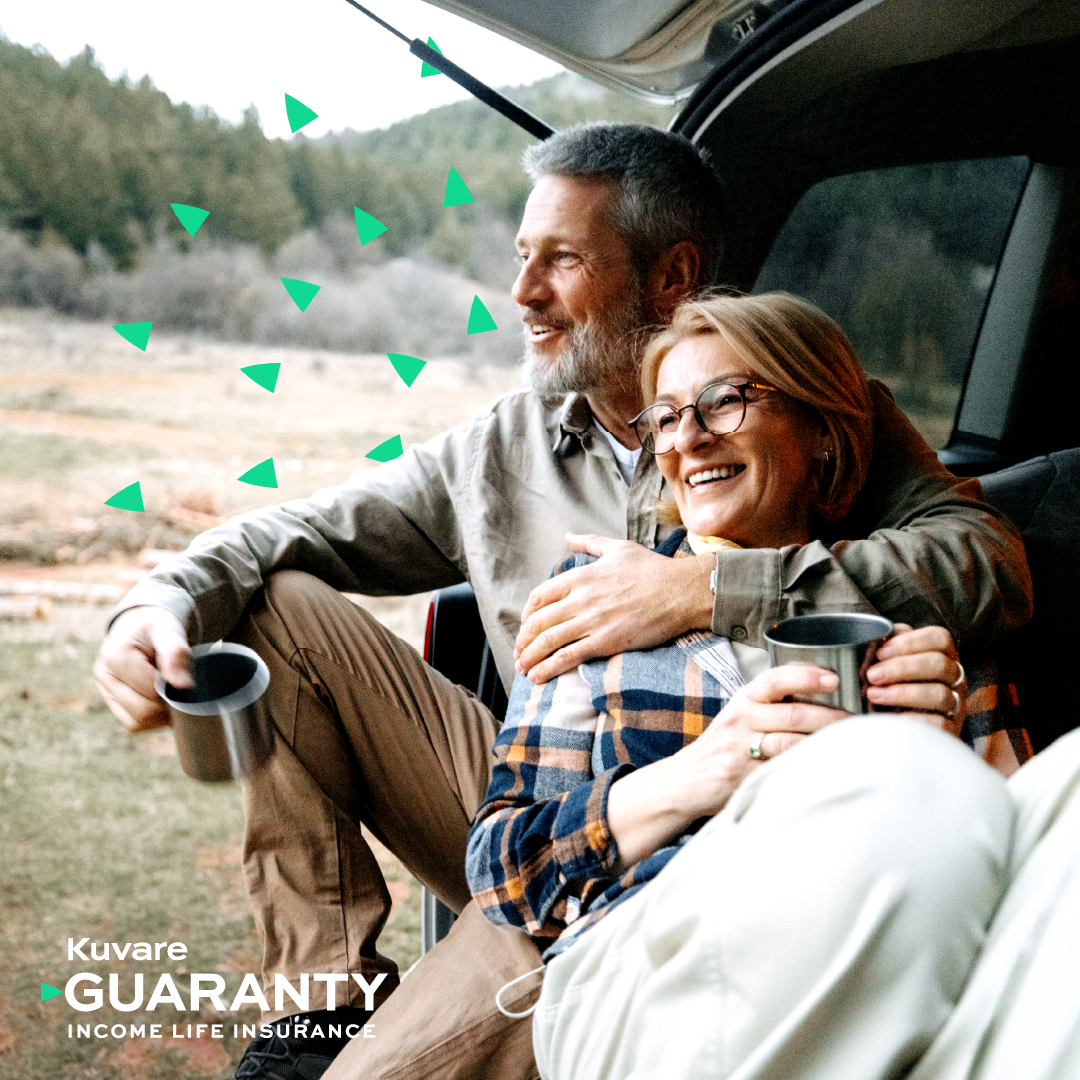 Middle aged couple happily sitting together in the back of an SUV, looking out at a mountain scene