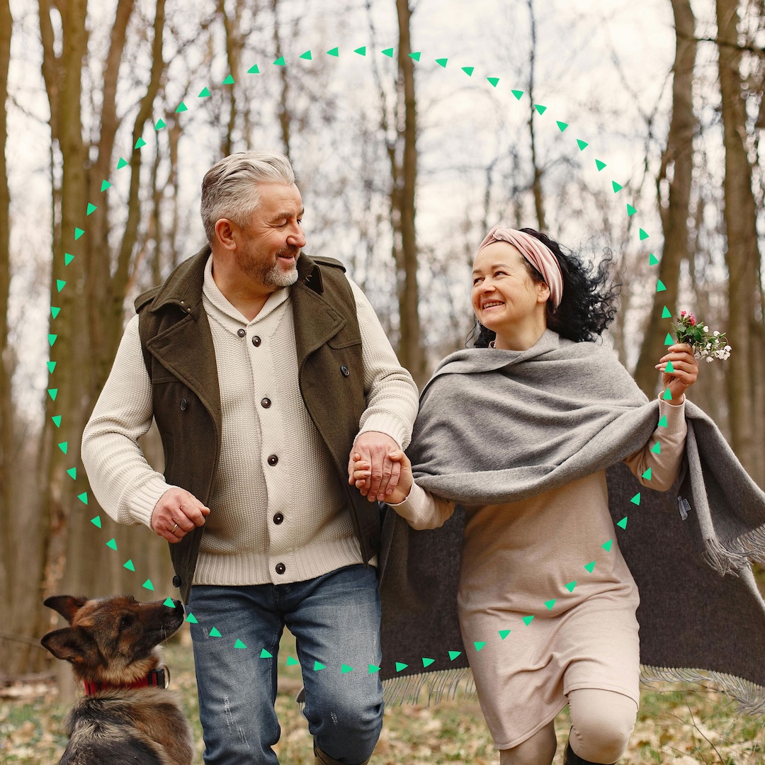 middle aged couple happily running in the woods