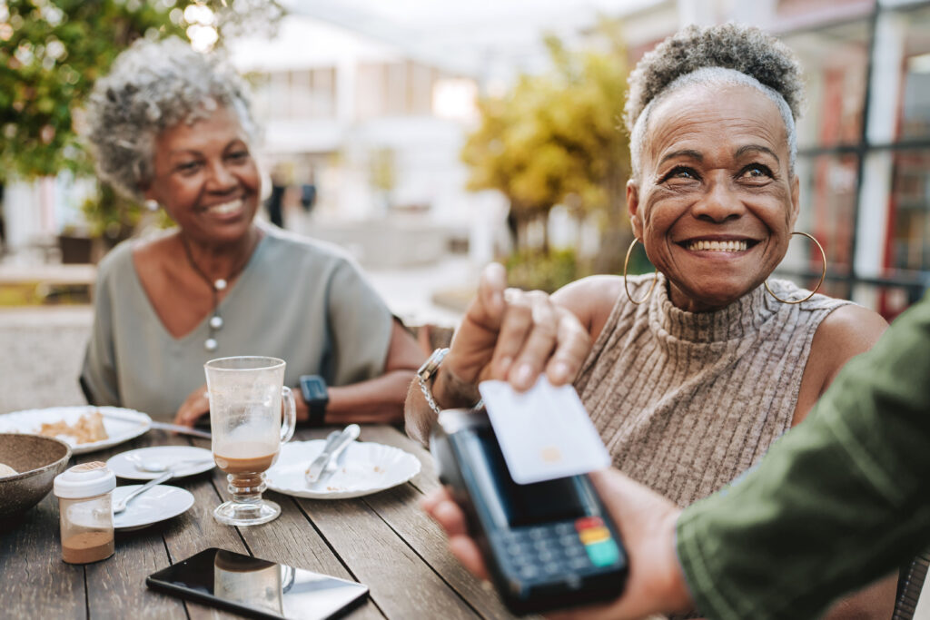 Two older women purchasing lunch with a credit card