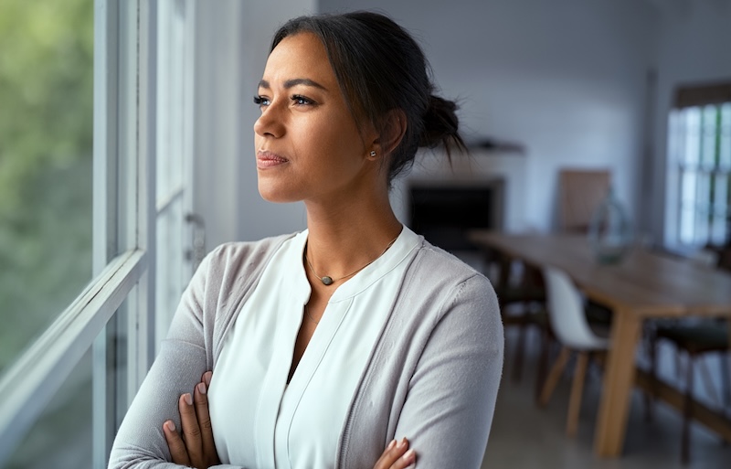 Young woman looking out window thoughtfully